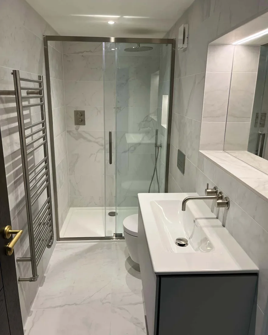 Marble tiled bathroom with wall-mounted vanity and black fittings