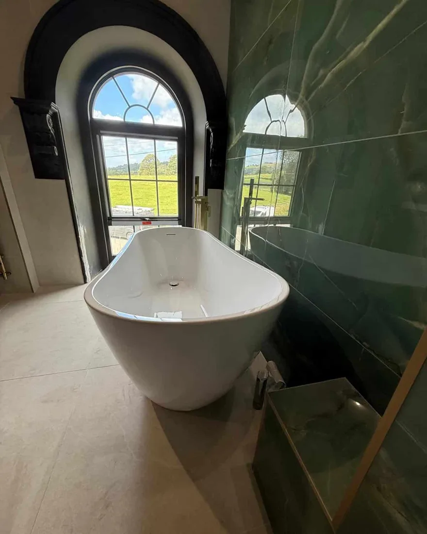 Freestanding bath with green marble feature wall